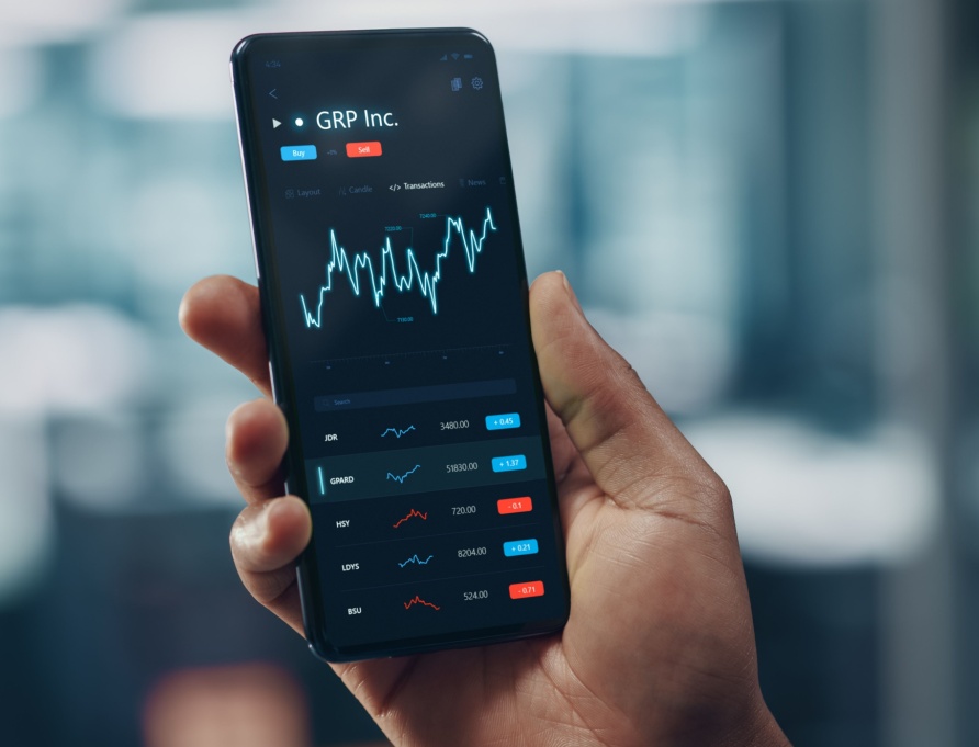 A man looking at stock market performance on his phone.