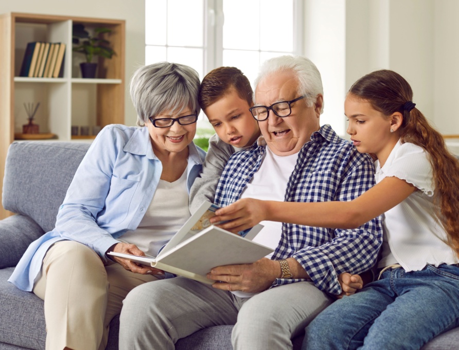 Grandparents looking at a photo album with their grandchildren.