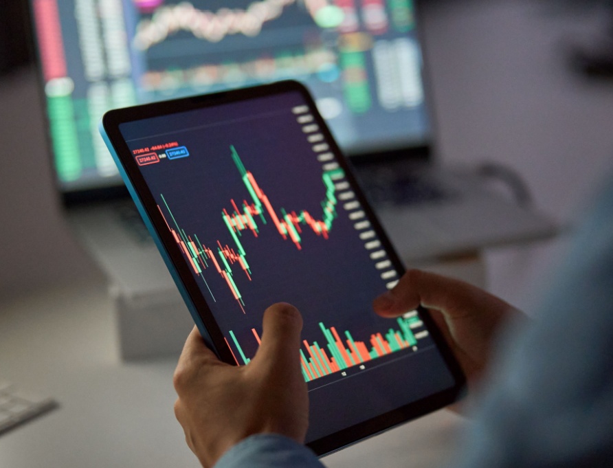 A person looking at a stock market graph on a tablet.