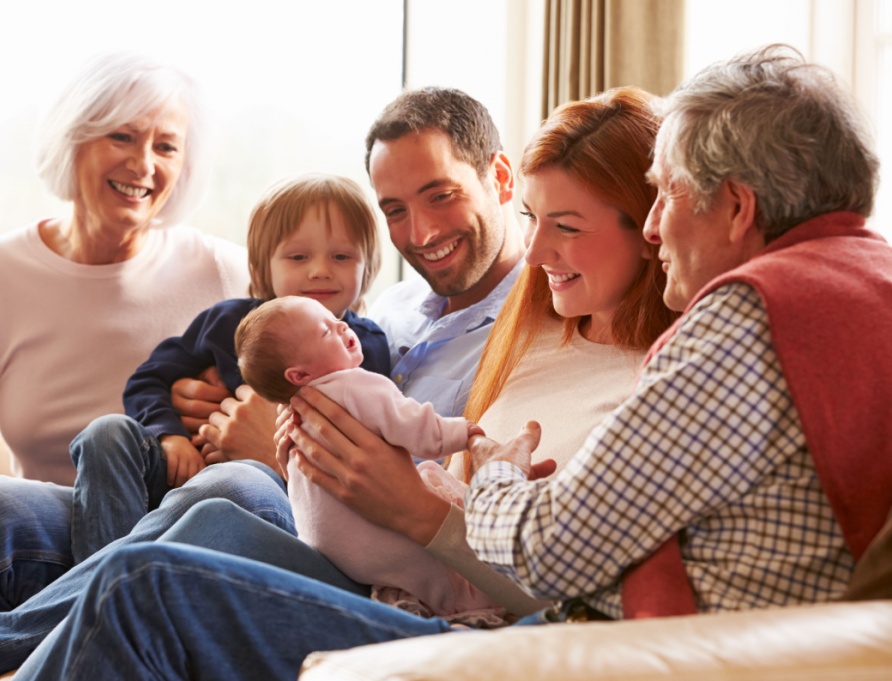 A multi-generational family sitting on the sofa.