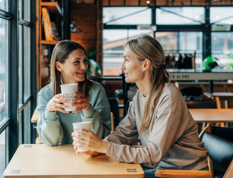 Two women talking in a coffee shop.