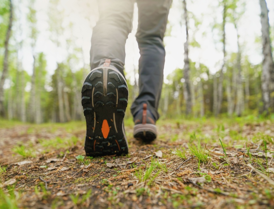 A close-up of a person walking in the woods.