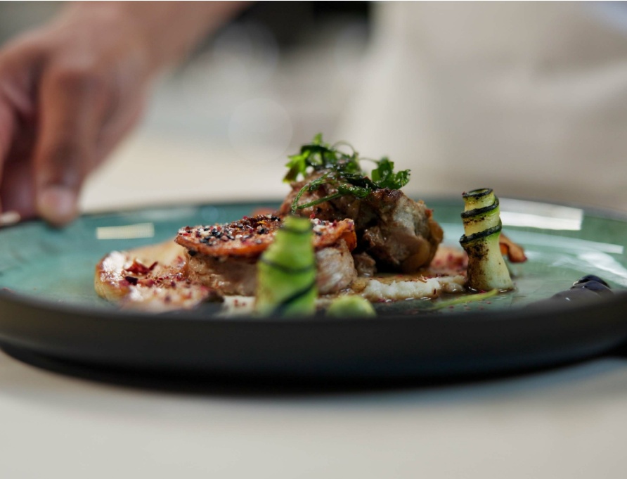 A chef prepares a dish in a fine dining restaurant.