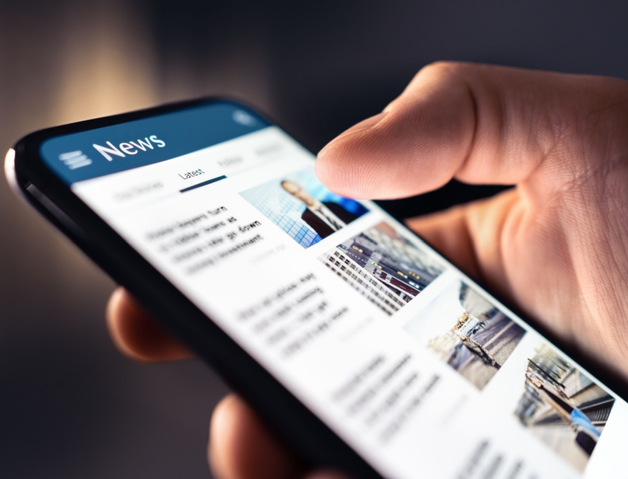 A person looking at a news feed on their phone.
