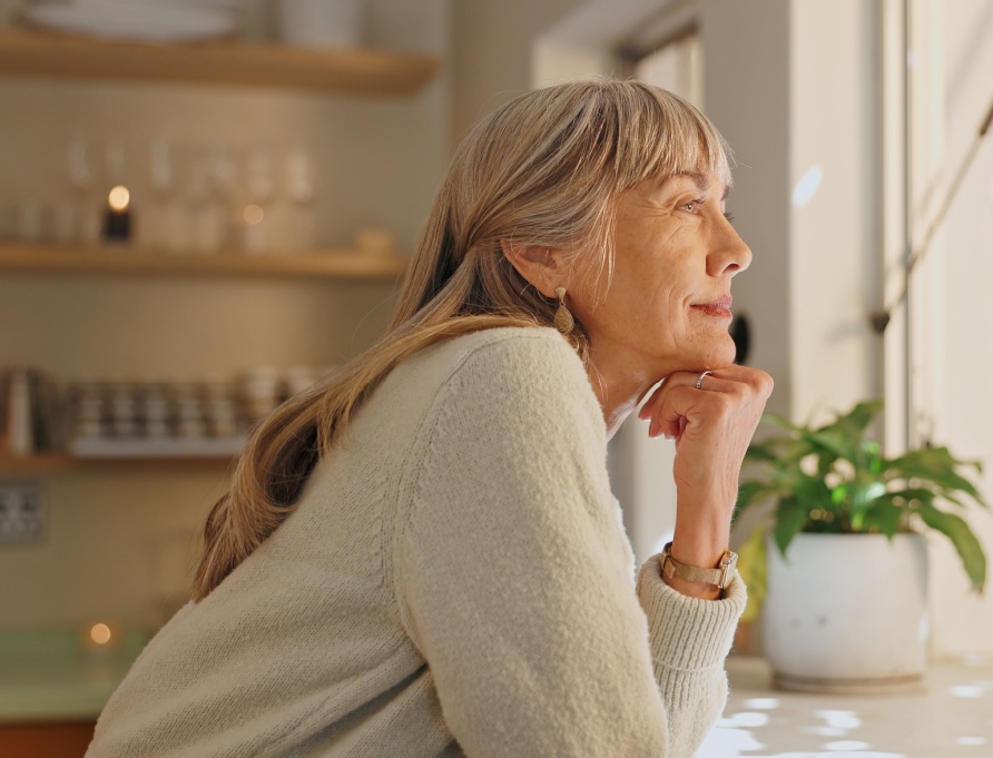 A woman looking out of the window at home.