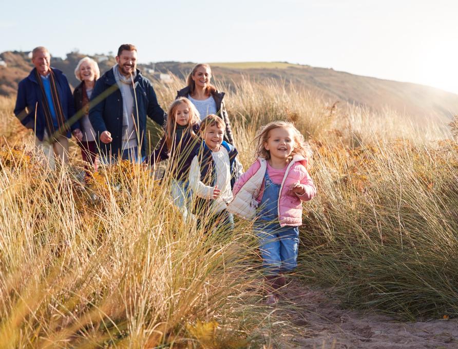 A family walking through dunes.