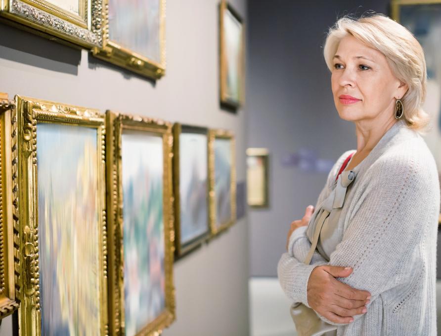A woman looking at art in a gallery.