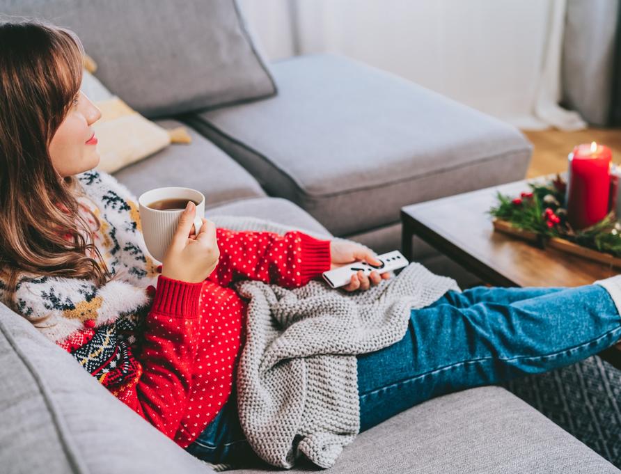 A woman relaxing wearing a Christmas jumper.