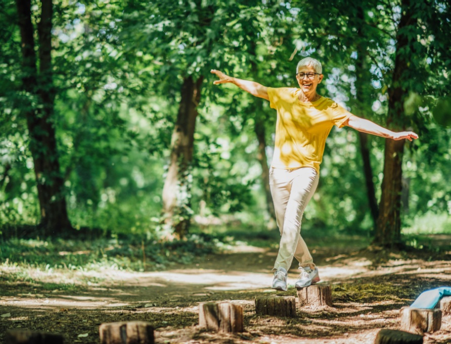 A woman doing balancing exercises outdoors.