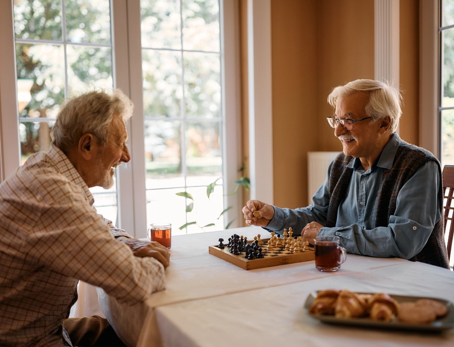 Two men playing chess at home.